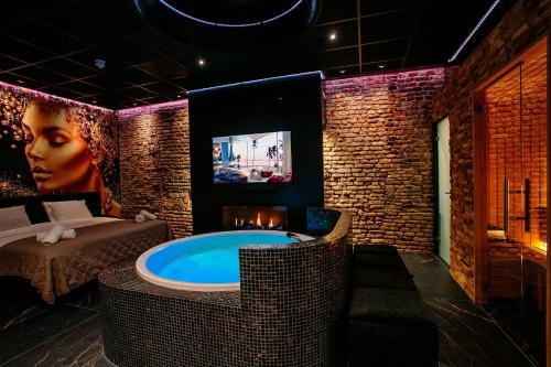 a room with a jacuzzi tub and a television at City Spa Nijmegen in Nijmegen