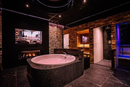 a large bathroom with a tub and a fireplace at City Spa Nijmegen in Nijmegen