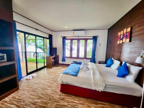 a bedroom with a large bed with blue pillows at Three Trees Samui Resort - Sarocha Villa in Lamai