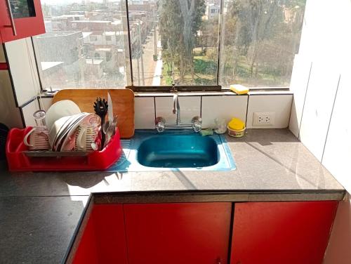 una pequeña cocina con fregadero y ventana en El copihue, en Tacna