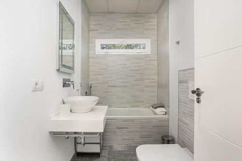 Baño blanco con lavabo y bañera en Chill out of City, en Pago del Humo