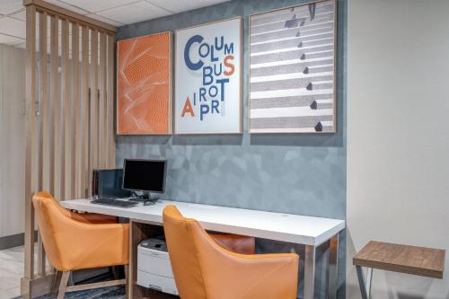 傑漢奈的住宿－哥倫布機場智選假日套房酒店，办公室配有桌椅和电脑