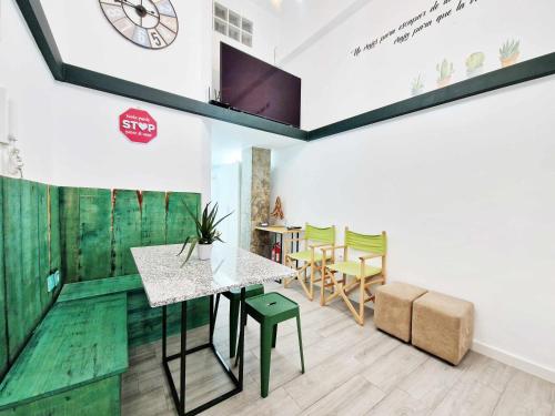 a room with a table and chairs and a clock on the wall at Alojamiento Simón 3 in Murcia