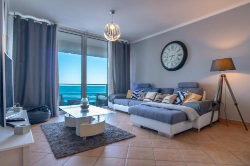 a living room with a couch and a clock on the wall at Apartment 7 on Paul do Mar Beach in Paul do Mar