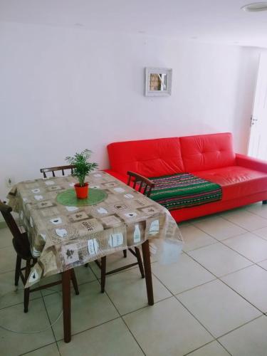 布希奧斯的住宿－Habitación con baño y cocina compartido-Porto da Barra，客厅配有红色的沙发和桌子