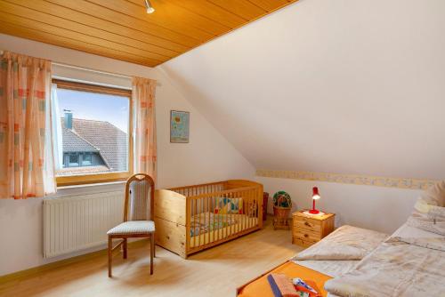 a bedroom with a crib and a window at Haus Felix in Neubulach