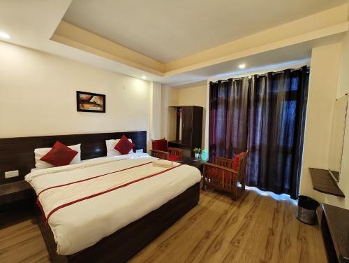 a bedroom with a large bed and a large window at Hotel The Narayani Continental in Gangtok