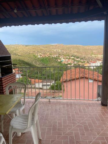 un balcon avec une table et des chaises et une vue dans l'établissement Excelente Casa em Diamantina com Vista para Serra, à Diamantina