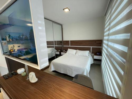 1 dormitorio con cama y espejo grande en Comodo y lujos monoambiente Equipetrol NanoTec, en Santa Cruz de la Sierra
