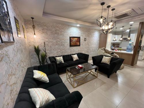 GOLD crest sunset luxury apartment في لاهور: غرفة معيشة مع أريكة وطاولة