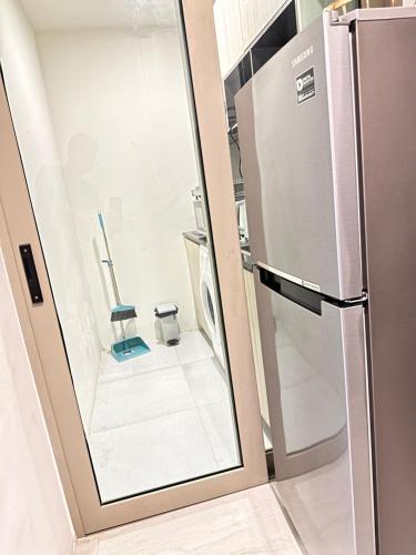 a glass door leading into a kitchen with a refrigerator at OCEANA HOME Phuket Kamala in Phuket Town