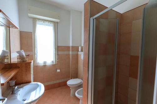 a bathroom with a toilet and a sink and a shower at Residence Rivaverde in Marina di Ravenna