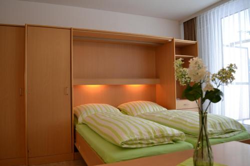 a bedroom with two beds and a vase of flowers at fewo-sporer in Sankt Englmar