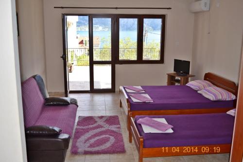 a room with two beds and a couch and a window at Apartments Sevaljevic in Kotor