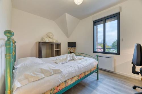 Schlafzimmer mit einem Bett und einem Fenster in der Unterkunft *Le Hameau Paisible : *Maison de Campagne* 