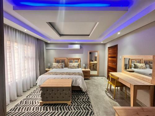 a bedroom with two beds and a blue ceiling at EDEN BOUTIQUE HOTEL in Kokstad