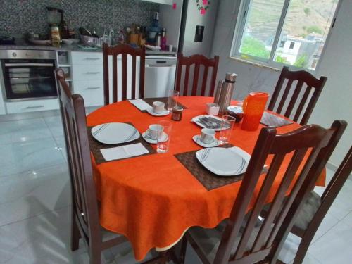 a dining room table with an orange table cloth on it at Bentub home in Ribeira Grande