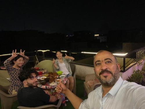 un grupo de personas sentadas alrededor de una mesa en una fiesta en Jana Pyramids view inn en El Cairo