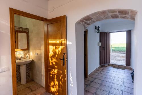 een hal met een badkamer met een wastafel en een deur bij EL NOGAL in Fuente Palmera