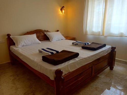 1 dormitorio con 1 cama con 2 toallas en SAI HOMESTAY, en Agonda