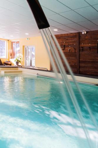 a swimming pool with water coming out of it at Hotel Spa L'Equipe in Molines-en-Queyras