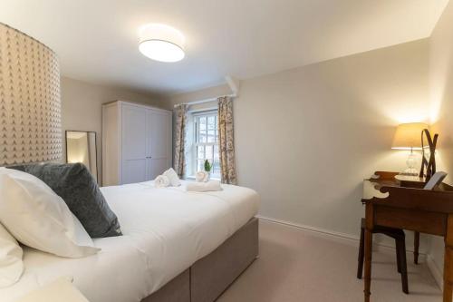 a bedroom with a bed and a desk and a window at Cosy & Peaceful Self Contained Home in Montpellier in Cheltenham