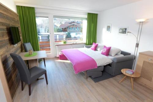 1 dormitorio con cama, sofá y mesa en Appartement „Klein & Fein“, en Bolsterlang