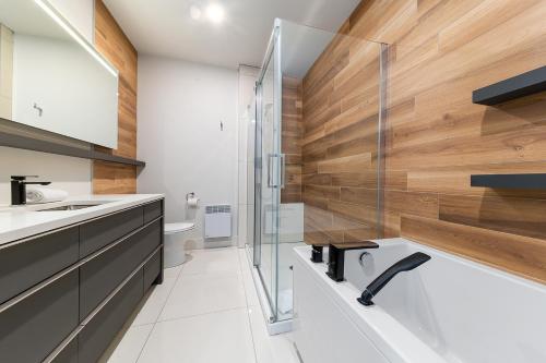 a bathroom with a glass shower and a sink at Les Appartements du Massif de Charlevoix in Petite-Rivière-Saint-François