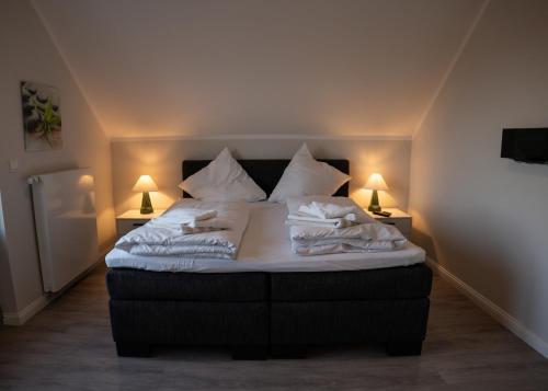 ハイリゲンハーフェンにあるOstsee - Appartement Nr 83 "Durchblick" im Strand Resortのベッド(白いシーツ、枕付)
