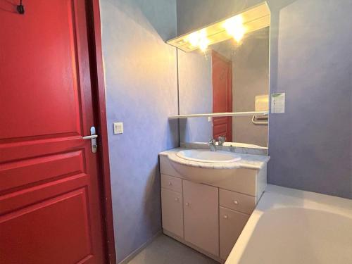 een badkamer met een witte wastafel en een rode deur bij Appartement Pelvoux, 2 pièces, 6 personnes - FR-1-330G-141 in Pelvoux