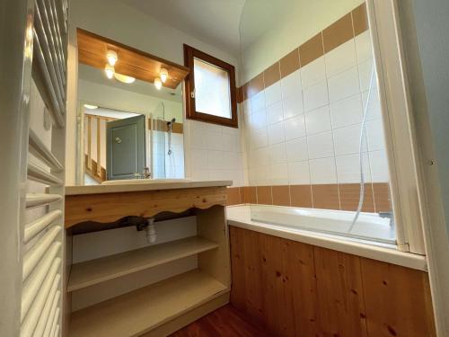 uma casa de banho com uma banheira, um lavatório e um espelho. em Chalet Le Dévoluy, 3 pièces, 4 personnes - FR-1-525-270 em Le Dévoluy