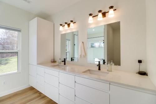 a white bathroom with two sinks and a large mirror at Gorgeous Harrison Getaway with Patio and Kayak! in Harrison