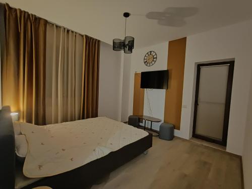 a bedroom with a bed and a clock on the wall at Studio Modern Class in Bucharest