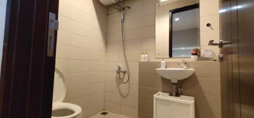 a bathroom with a sink and a toilet and a mirror at Regentown Home near ICE BSD in Cilandak