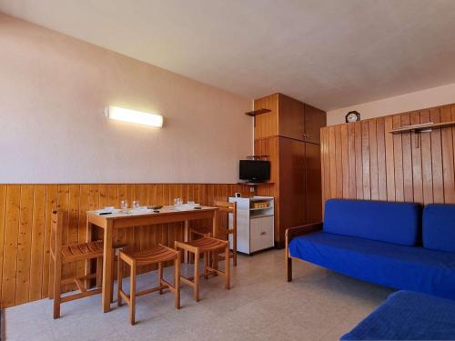 un salon avec un canapé bleu et une cuisine dans l'établissement Studio cosy 4 pers avec terrasse, proche pistes et commerces - FR-1-525-261, à Saint-Étienne-en-Dévoluy