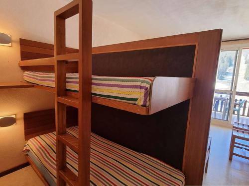 Ce lit superposé se trouve dans un dortoir avec une échelle. dans l'établissement Studio cosy 4 pers avec terrasse, proche pistes et commerces - FR-1-525-261, à Saint-Étienne-en-Dévoluy