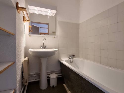 La salle de bains est pourvue d'un lavabo, d'une baignoire et de toilettes. dans l'établissement Appartement 2 pièces avec coin nuit, balcon exposé Sud-Ouest, parking gratuit, proche commerces et pistes - FR-1-525-263, à Saint-Étienne-en-Dévoluy