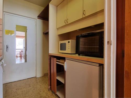 une petite cuisine avec un micro-ondes et un réfrigérateur dans l'établissement Studio chaleureux - 4 pers, proche pistes, Wifi, parking, animaux acceptés - FR-1-525-269, à Saint-Étienne-en-Dévoluy