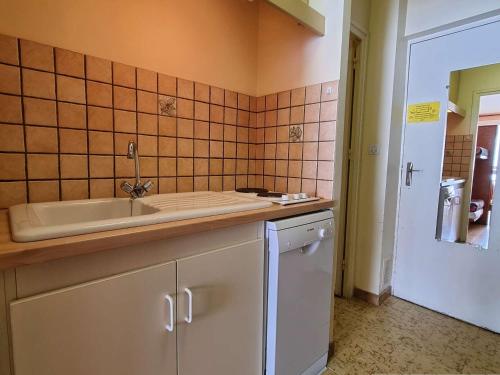Il dispose d'une cuisine avec un évier et un mur carrelé. dans l'établissement Studio chaleureux - 4 pers, proche pistes, Wifi, parking, animaux acceptés - FR-1-525-269, à Saint-Étienne-en-Dévoluy