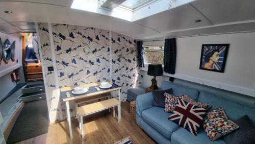 een woonkamer met een blauwe bank en een tafel bij The Royal Escape Windsor, Static Wide Beam Barge in Eton