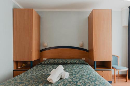 a bedroom with a bed with two towels on it at Hotel Bellavista in Grado
