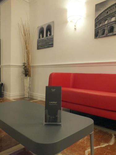 a living room with a red couch and a table at BB Hotels Smarthotel Bailey's in Rome