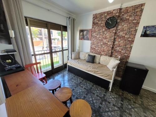 sala de estar con sofá y pared de ladrillo en Apartamento Lexus Beira Mar - apt 101, en Florianópolis
