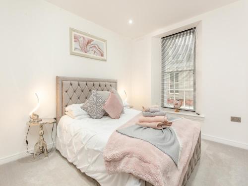 um quarto com uma cama com um cobertor rosa e uma janela em Spire View em Aberdeen