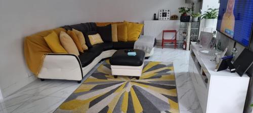ein Wohnzimmer mit einem schwarzen Sofa und gelben Kissen in der Unterkunft West Dulwich Home 28 Mins to London Victoria in London