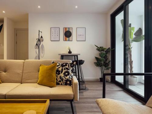 Luxe Pad London with Free Parking في برينتفورد: غرفة معيشة مع أريكة ومخدة صفراء