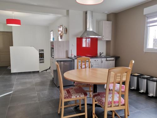 une cuisine avec une table et des chaises en bois dans l'établissement Chambres d'hôtes GIDY, à Gidy