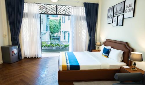 a bedroom with a bed and a large window at Covent Garden Hotel in Ho Chi Minh City