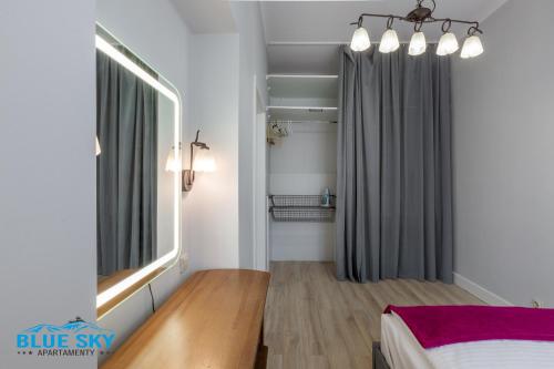 a bedroom with a bed and a large window at Apartament Blue Sky Jelenia Góra - blisko centrum in Jelenia Góra