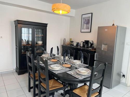 Saint-Julien-Beychevellebelle demeure médocaine charme et convivialité的一间带桌子和冰箱的用餐室